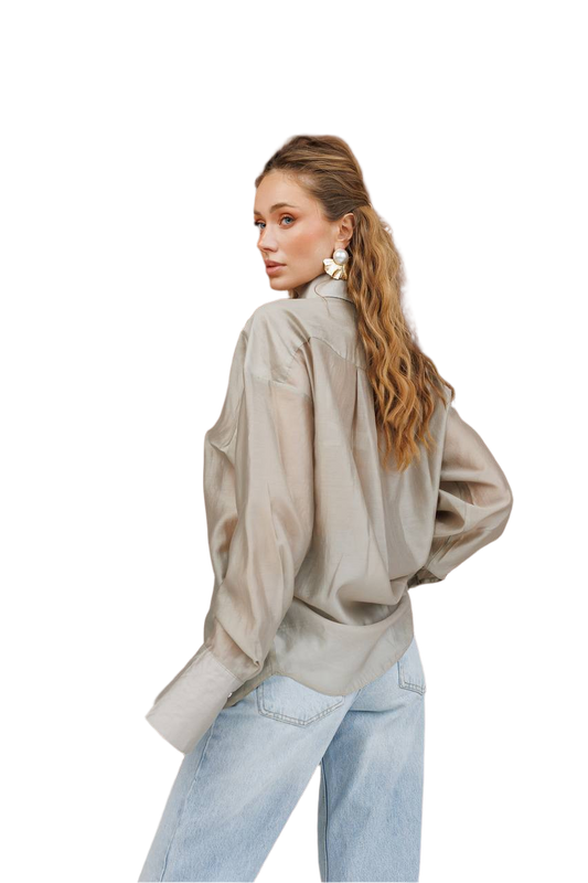Woman wearing a beige blouse and light blue jeans on a white background