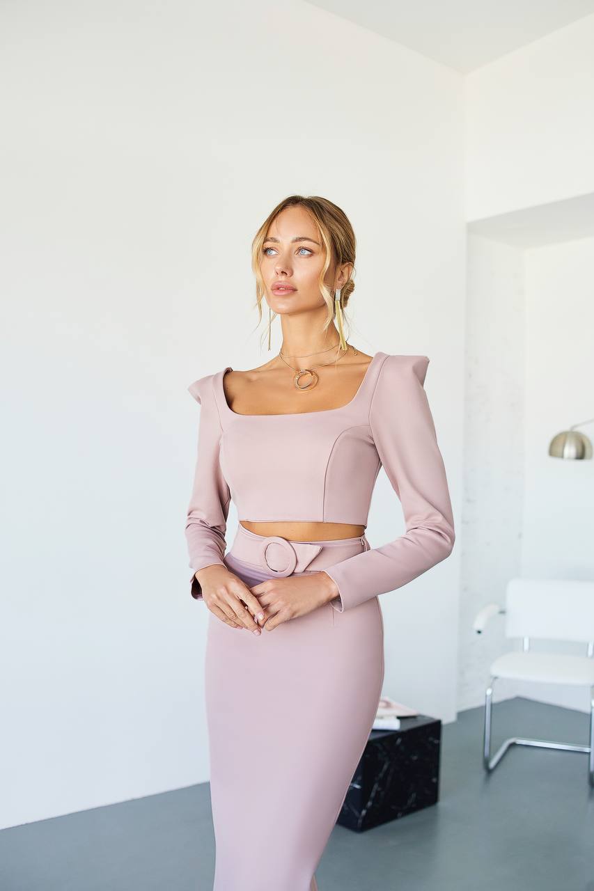 Woman wearing a pink outfit in a minimalistic room