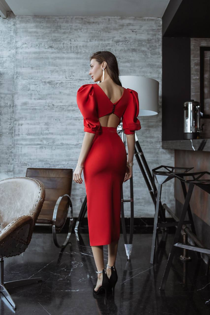 Woman in a red dress standing in a modern interior setting