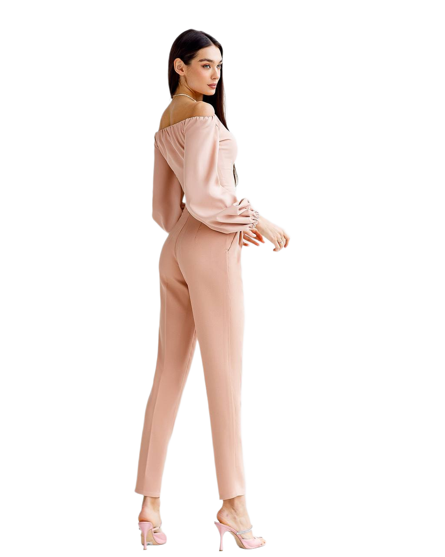 Woman wearing a beige off-shoulder top and pants on a white background