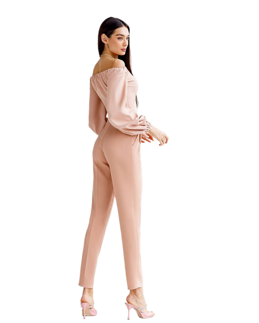 Woman wearing a beige off-shoulder top and pants on a white background