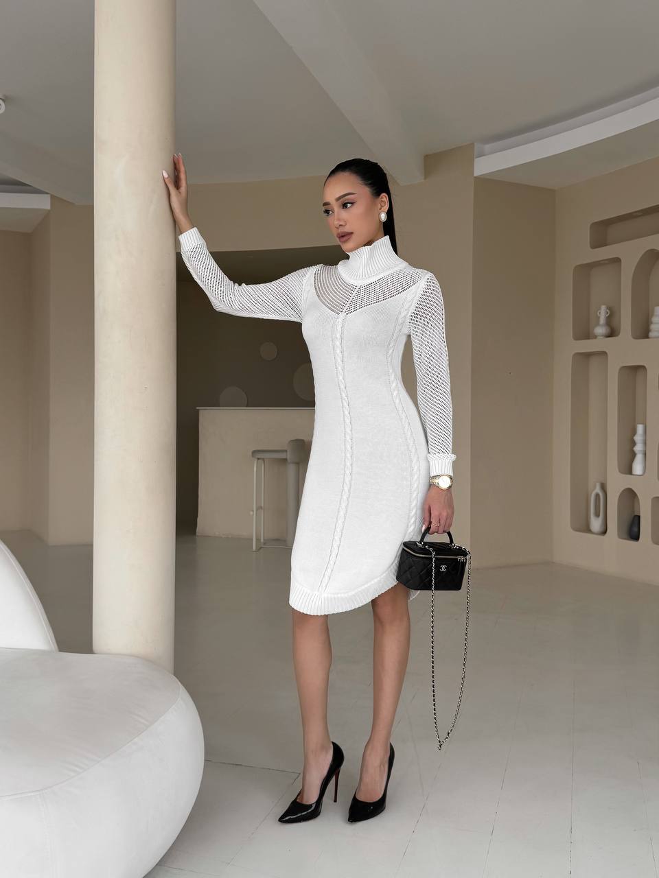 Woman in a white dress standing in a modern interior setting