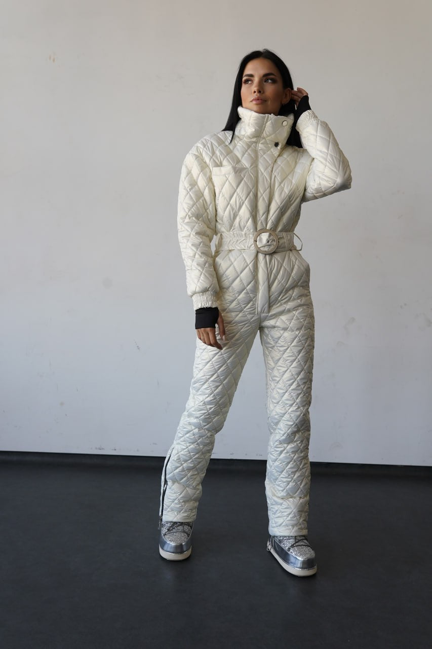 Person wearing a white quilted snowsuit against a plain background