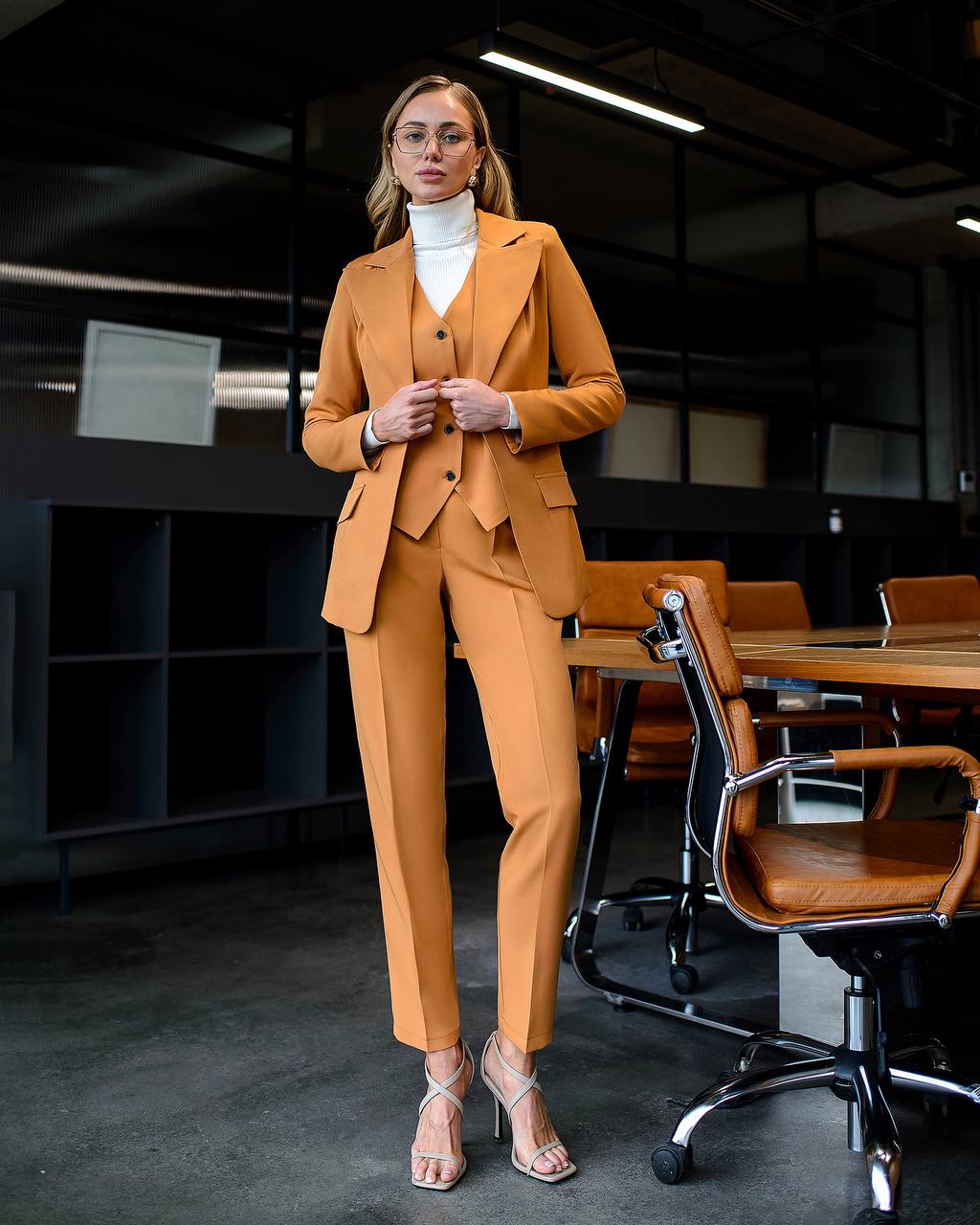 Woman in a mustard yellow suit standing in an office setting
