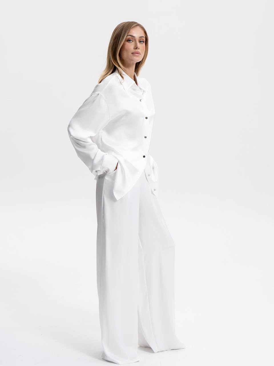 Woman wearing a long white dress against a white background