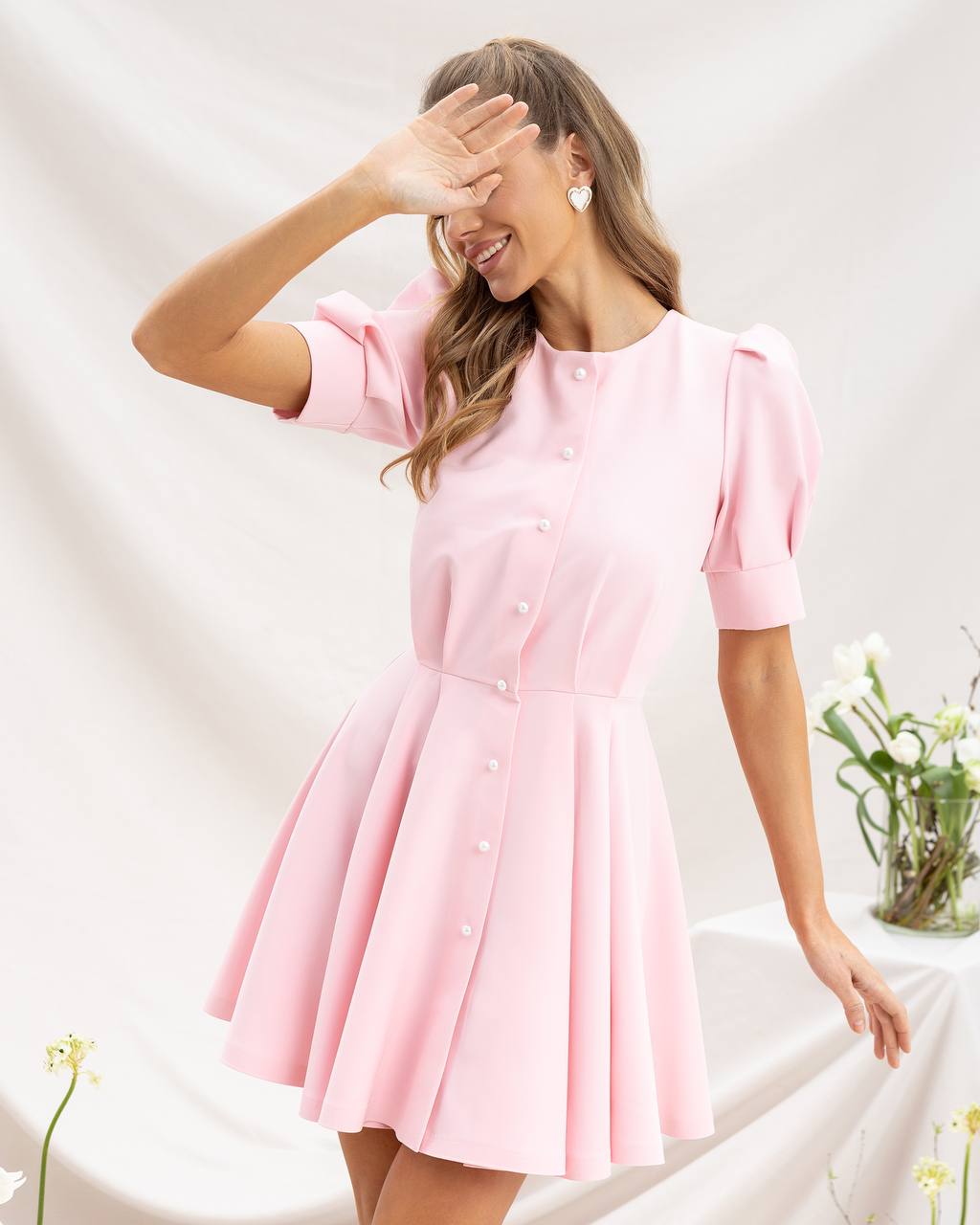 Woman wearing a pink dress with a white background