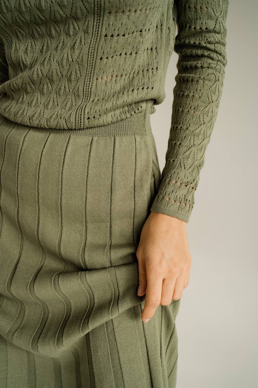Green ribbed sweater and skirt set on a neutral background