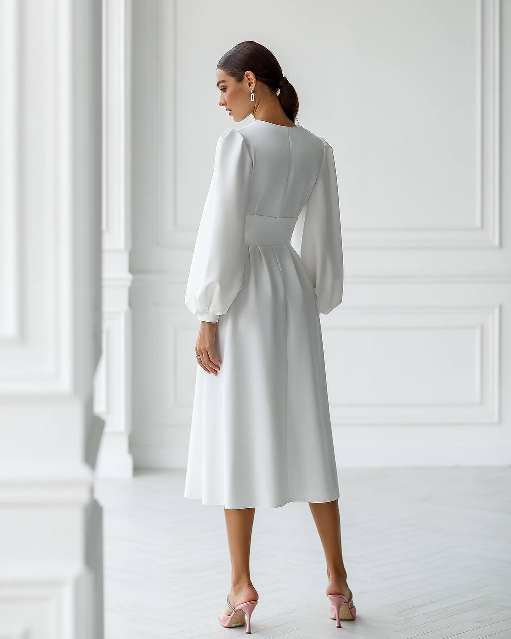 Woman wearing a white dress in a minimalistic setting