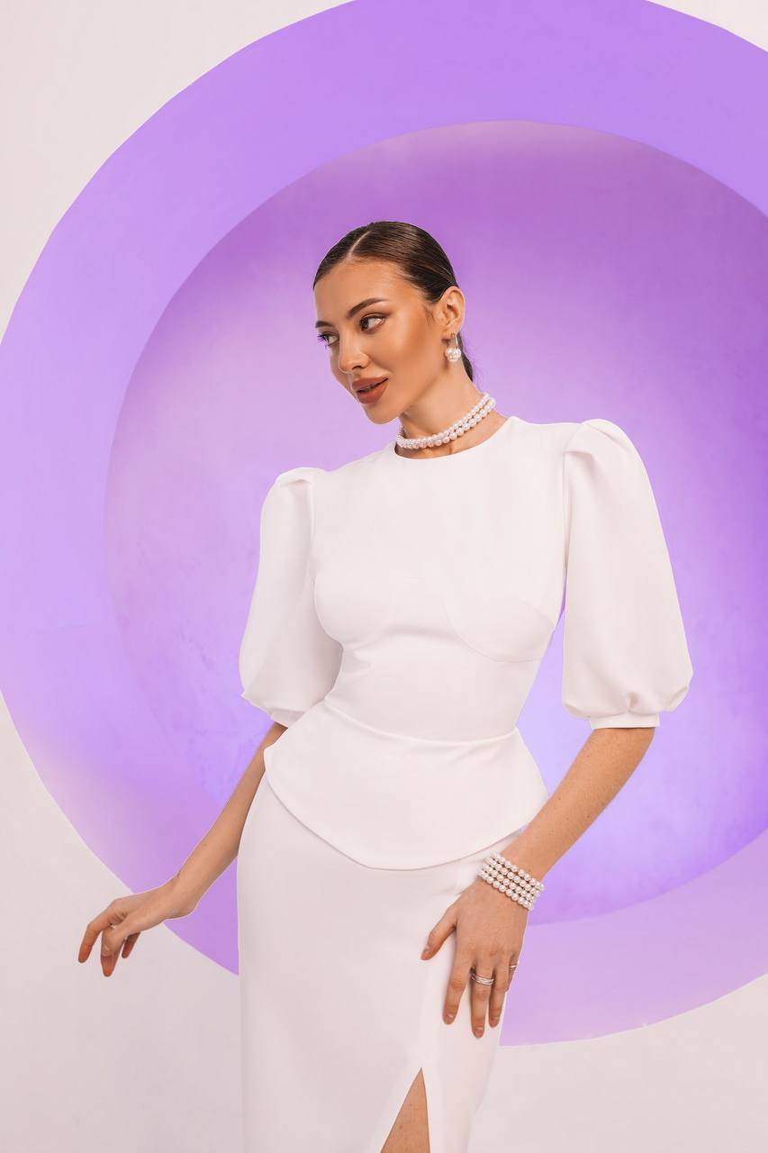 Woman in a white dress with puffed sleeves against a purple circular background
