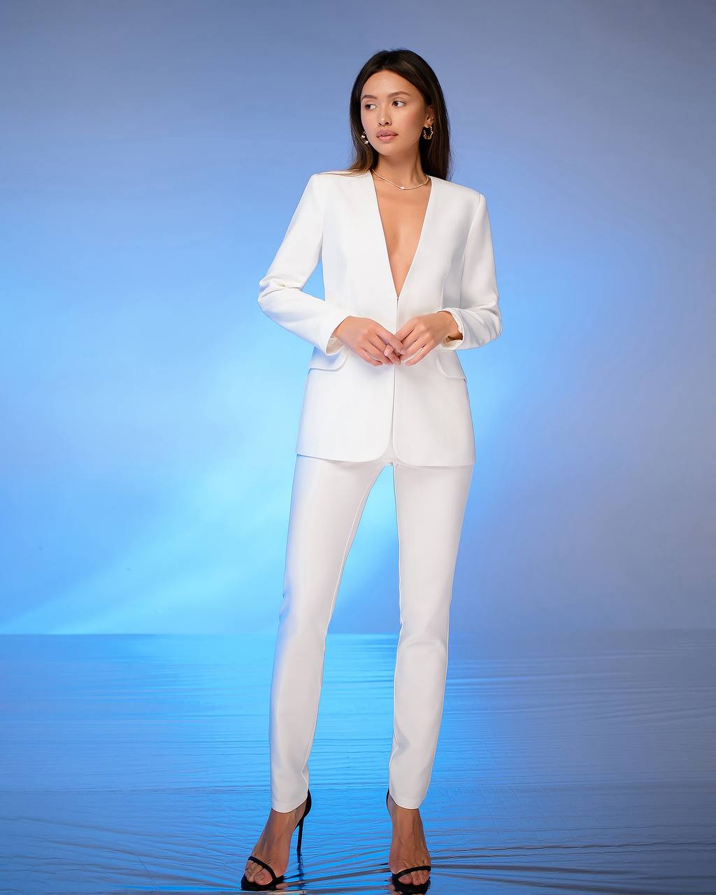 Woman wearing a white suit against a gradient blue background