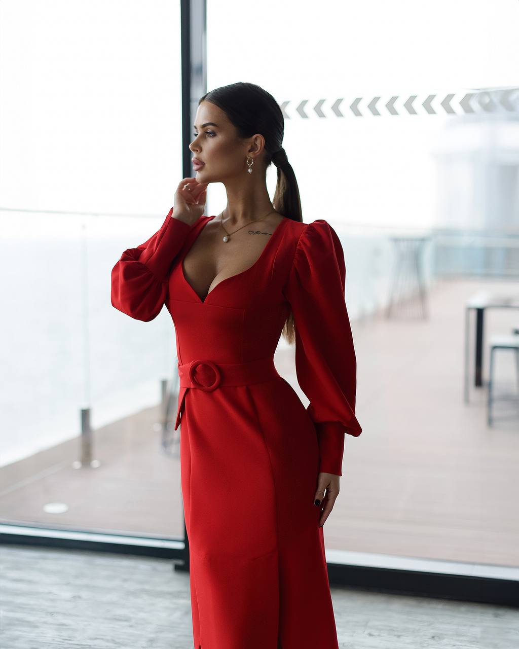 Woman in a red dress standing in a modern indoor setting