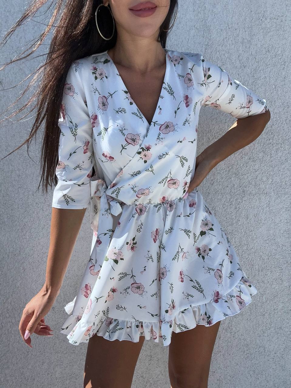 Woman wearing a floral dress against a gray background