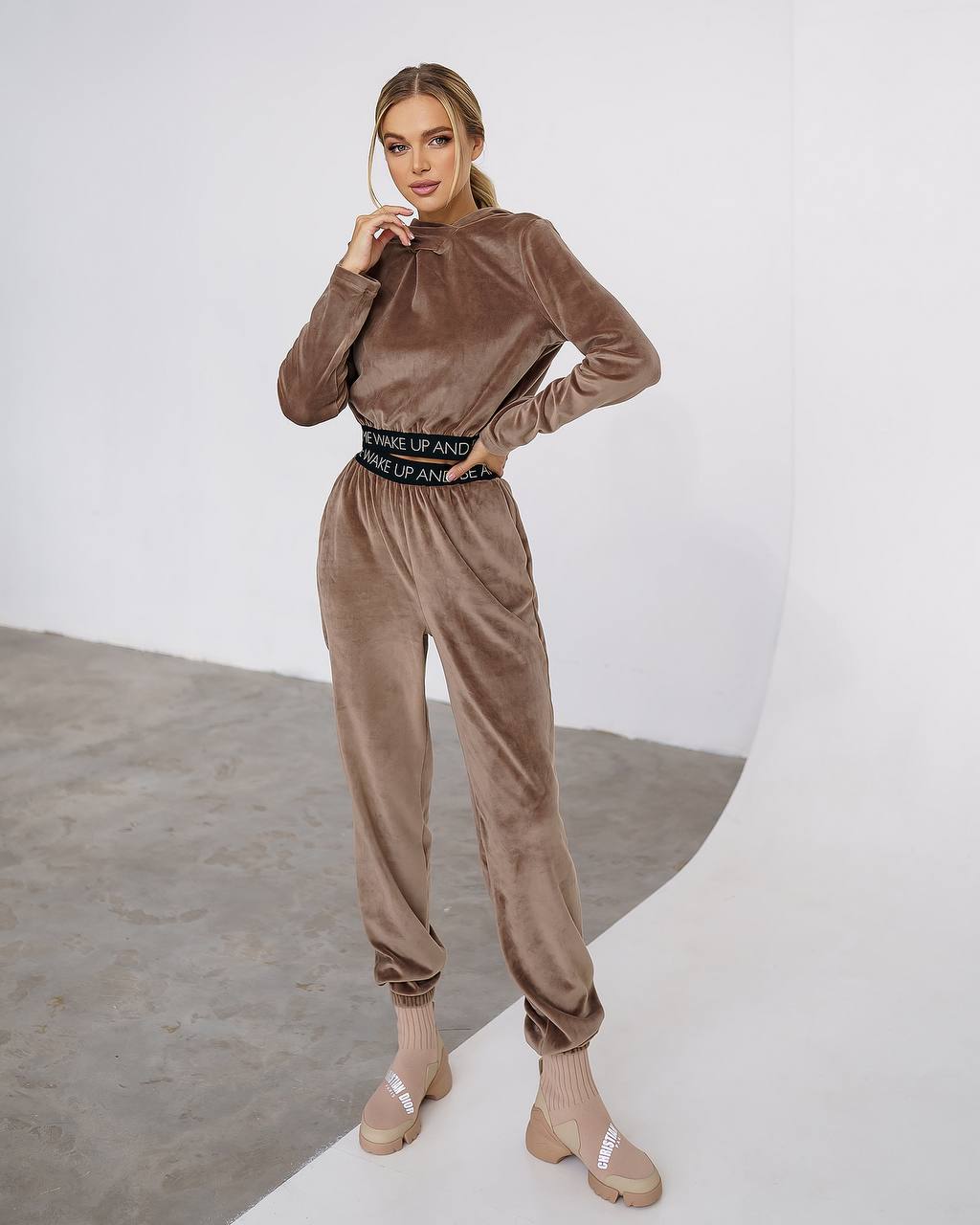 Woman wearing a brown velvet outfit with a white background