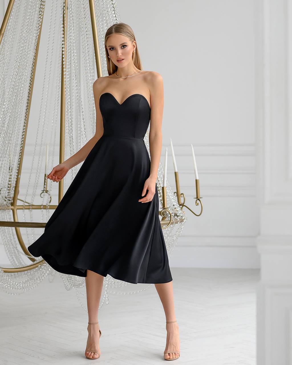 Woman wearing a black strapless dress in an elegant indoor setting