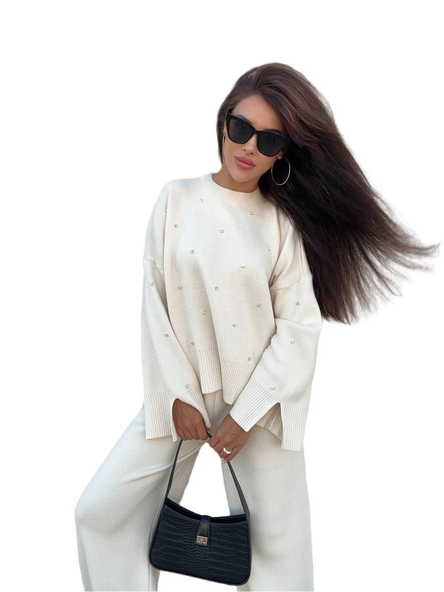 Woman wearing a white outfit with a black handbag on a white background