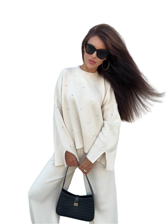 Woman wearing a white outfit with a black handbag on a white background