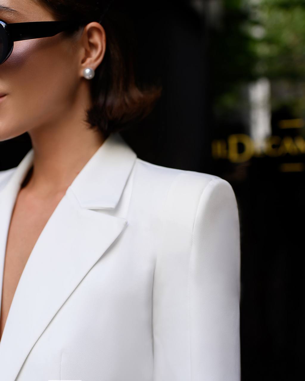 Person wearing a white blazer with a blurred background
