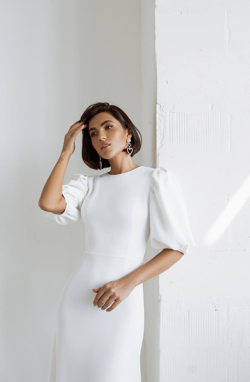 Woman wearing a white dress against a plain background