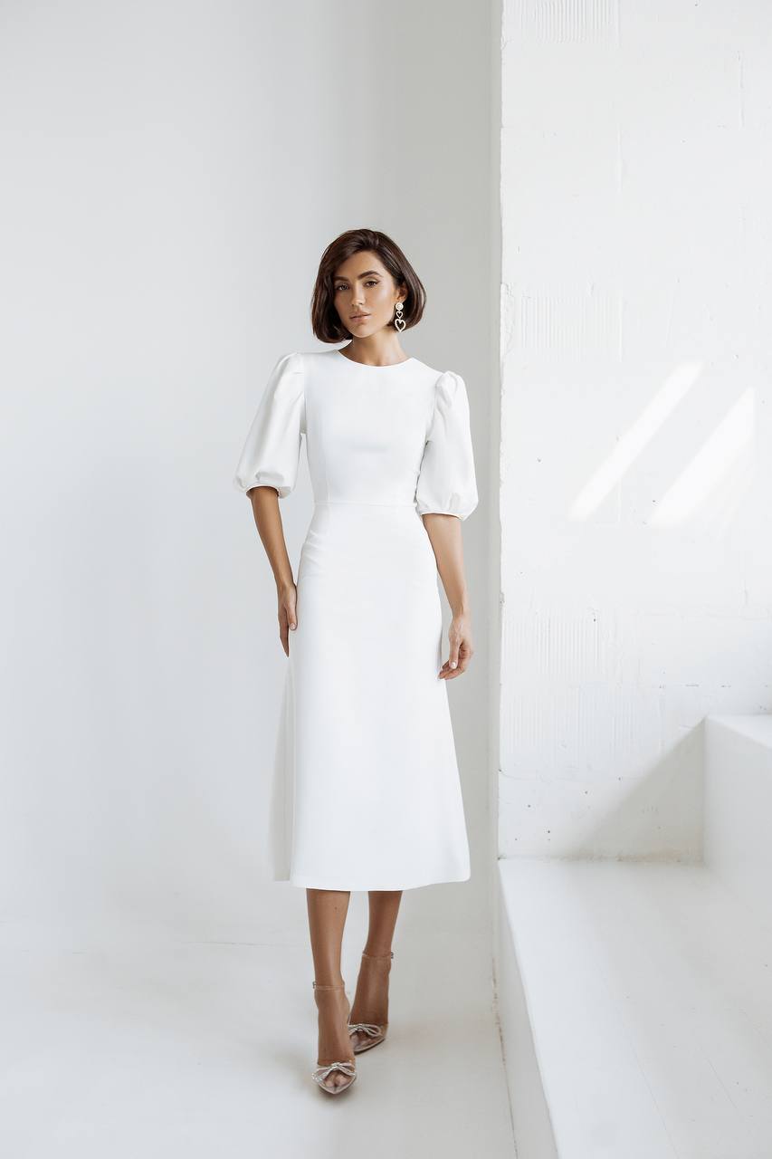 Woman wearing a white dress against a white background