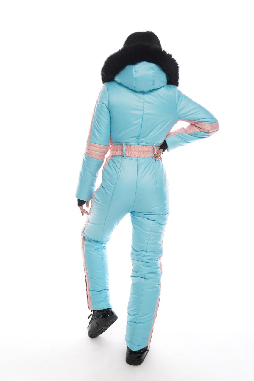 Person wearing a light blue snowsuit with black boots on a white background