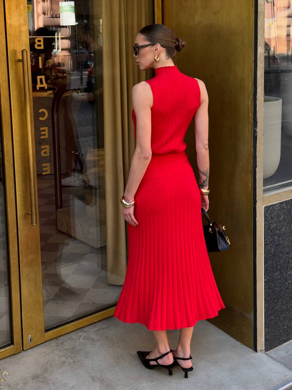 Woman in a red dress standing outside a building