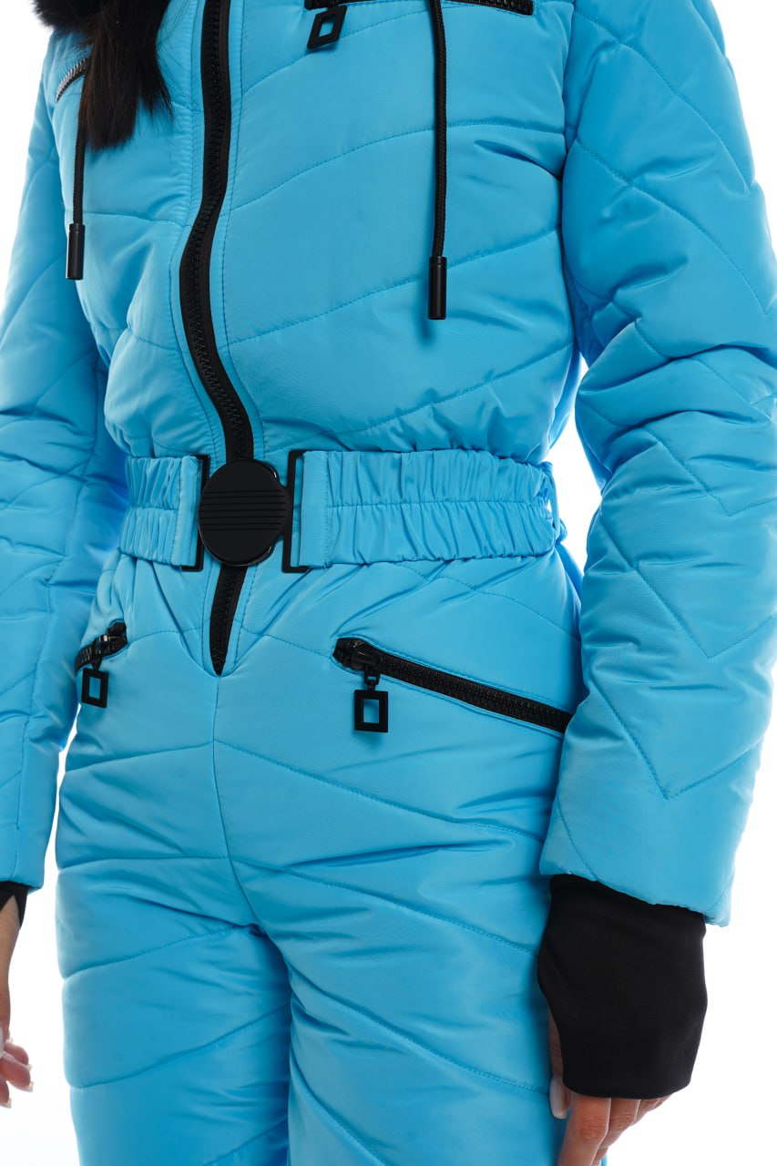 Person wearing a blue snowsuit with black zippers on a white background