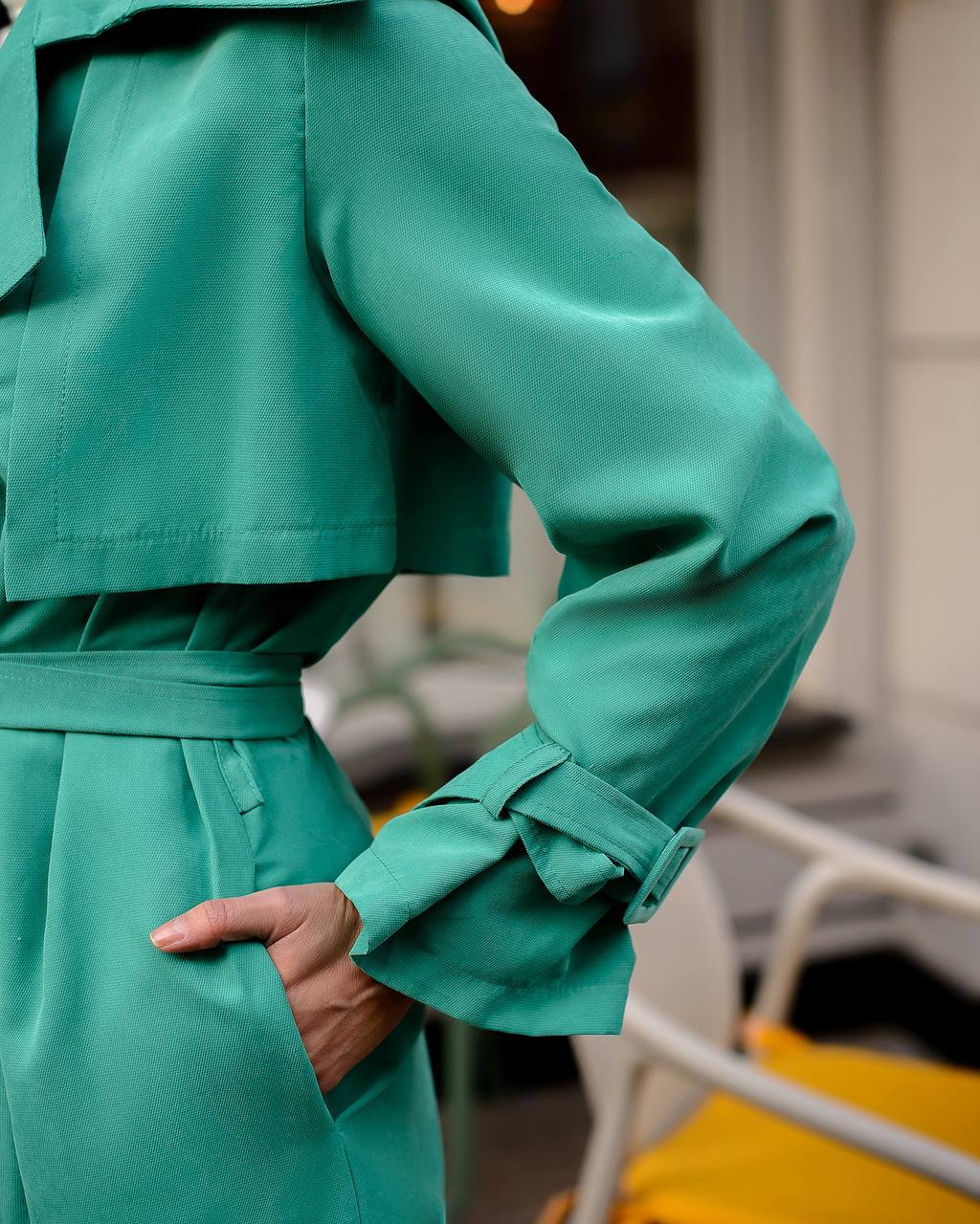 Green trench coat with a blurred background