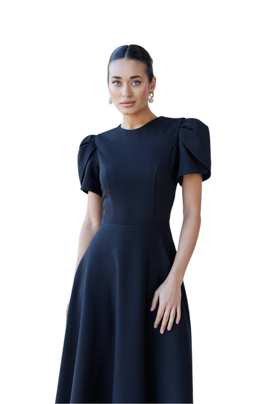 Woman wearing a dark blue dress with puff sleeves on a white background