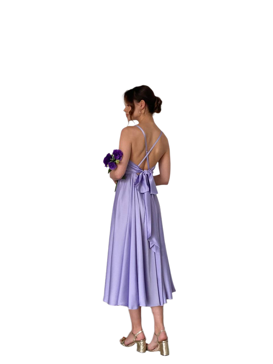 Woman wearing a purple dress holding flowers on a white background