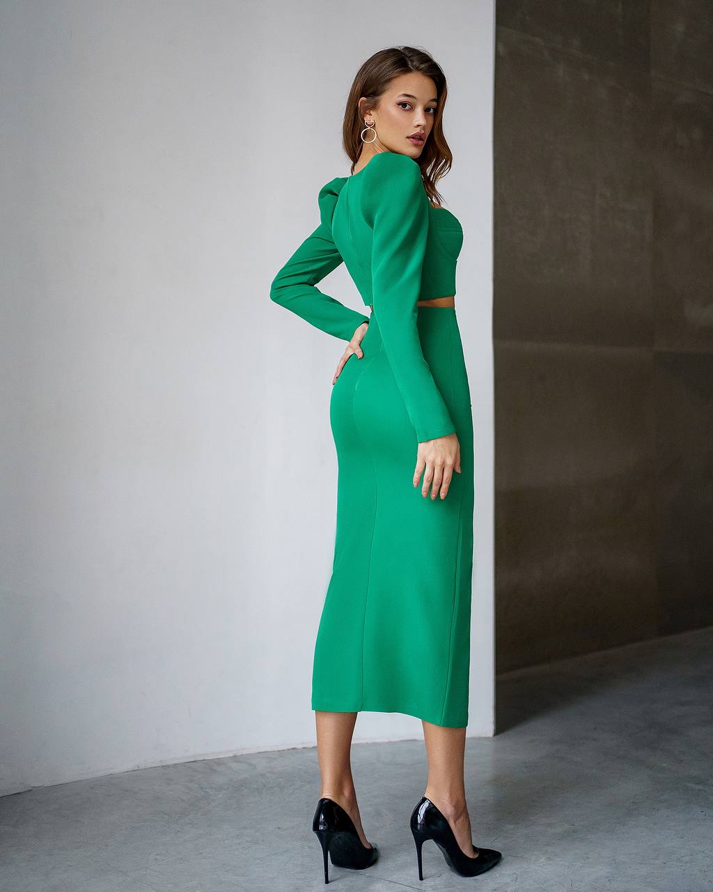 Woman wearing a green dress against a neutral background