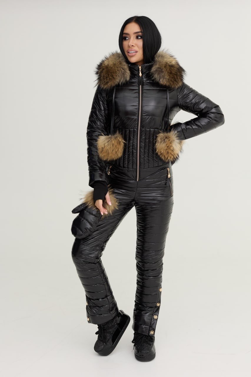 Person wearing a black snowsuit with fur trim on a white background