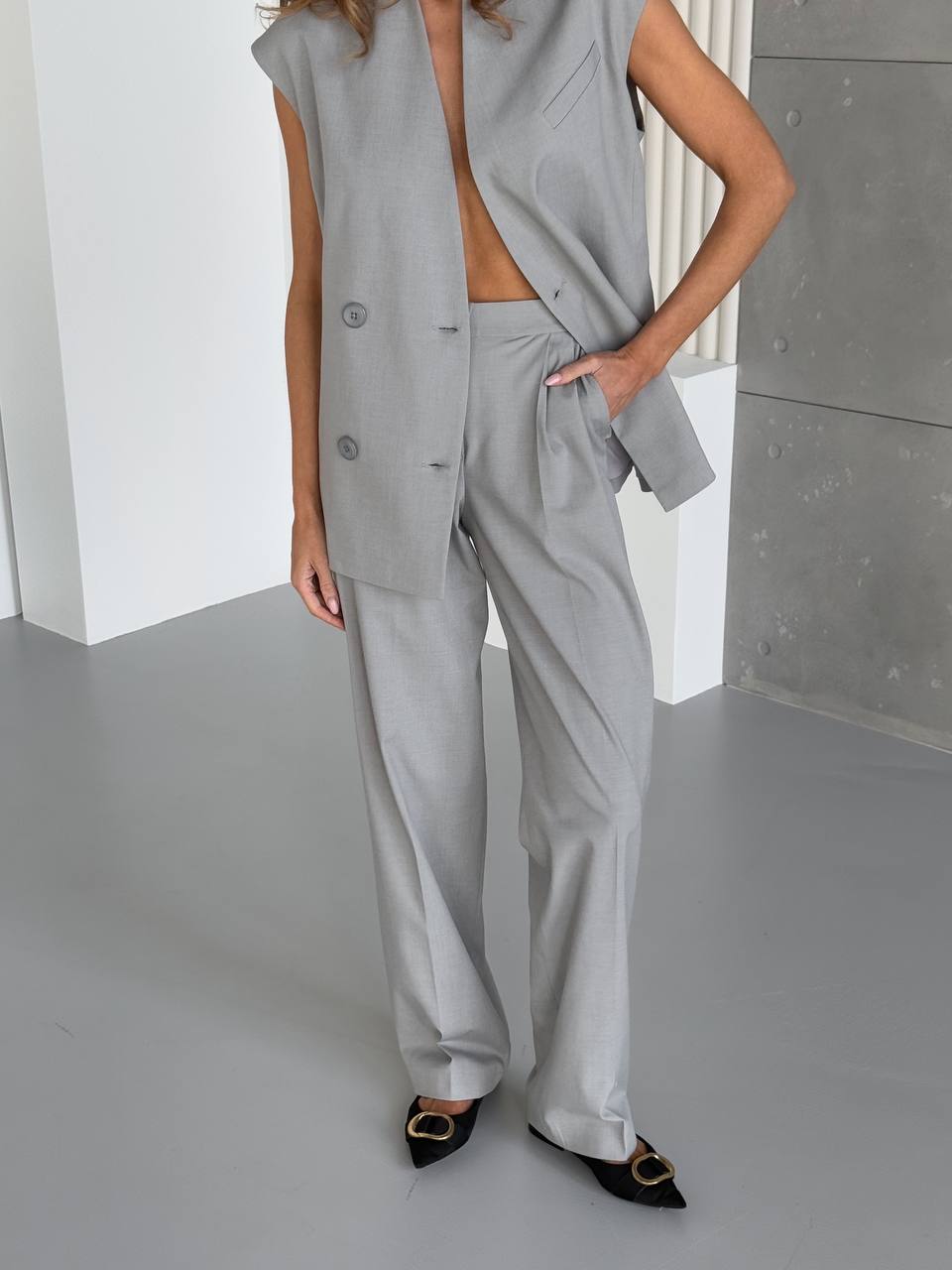Person wearing a gray suit with a plain background