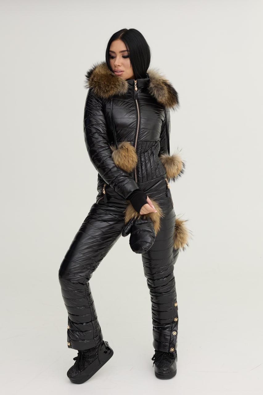 Person wearing a black snowsuit with fur trim on a white background