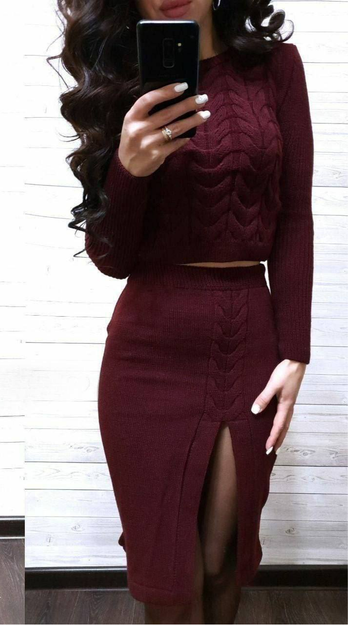 Person wearing a burgundy sweater and skirt set, taking a mirror selfie.
