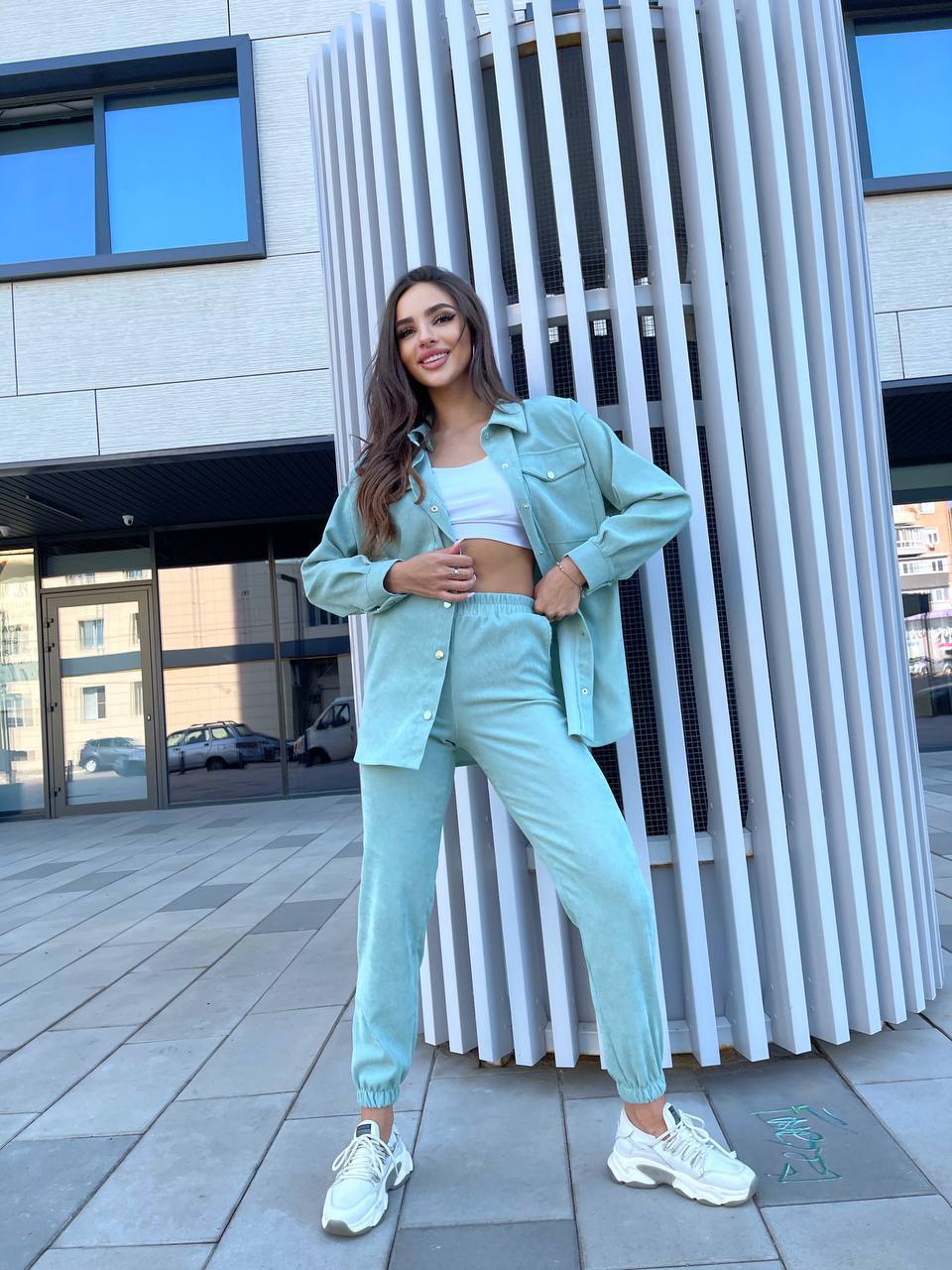 Woman in a mint green outfit standing in an urban setting