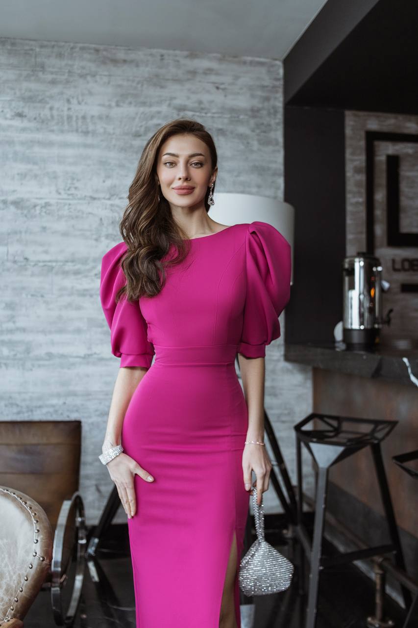 Woman in a pink dress standing in an indoor setting