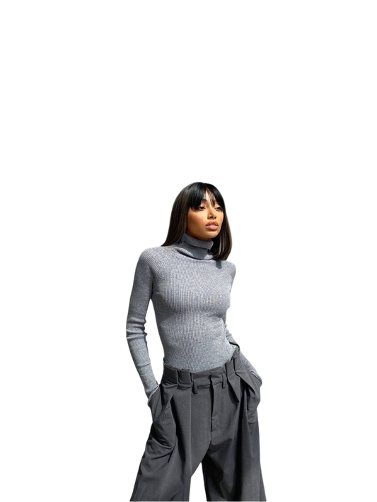 Person wearing a gray turtleneck and wide-leg pants on a white background