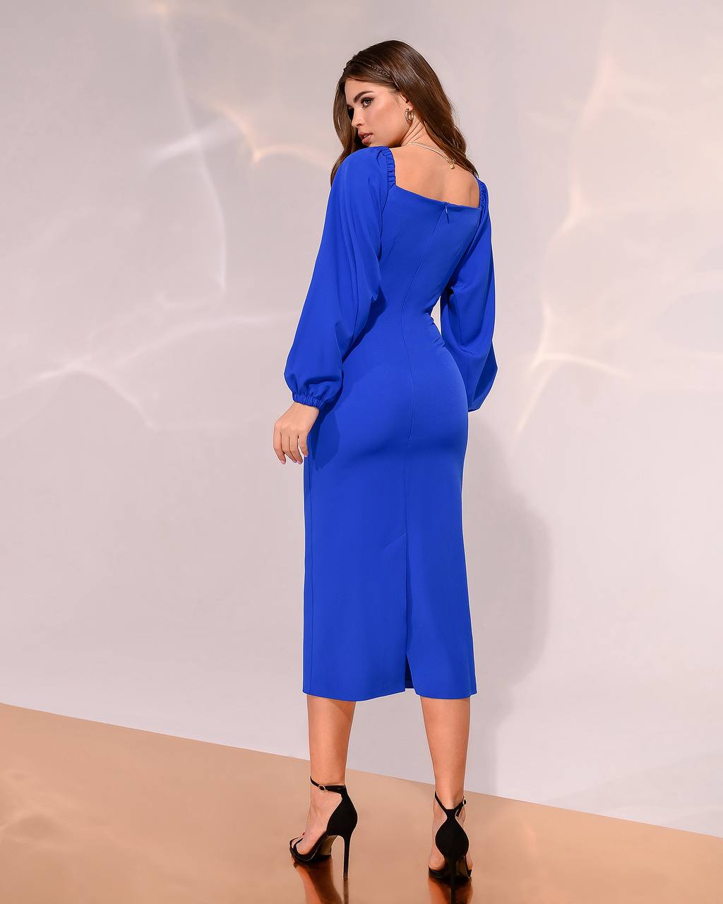 Woman wearing a blue off-shoulder dress against a white background