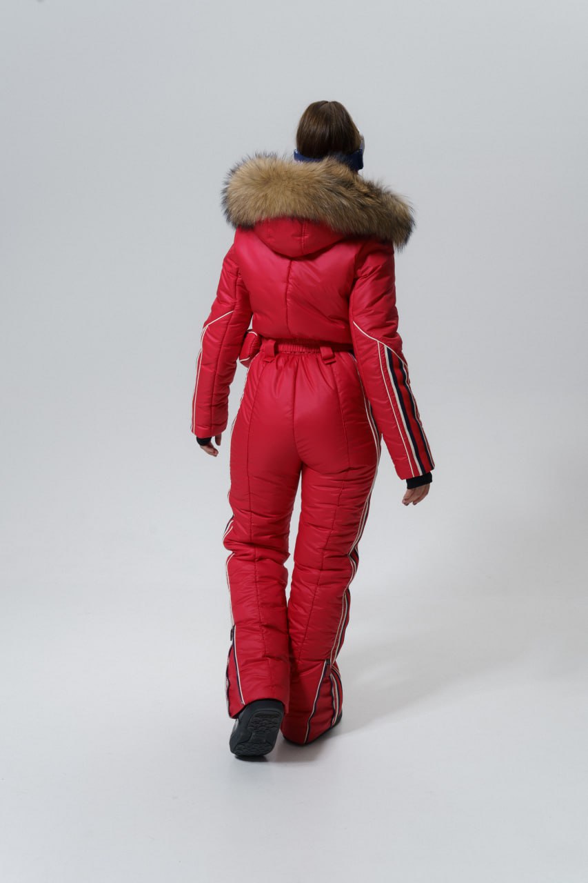 Person wearing a red snowsuit with fur hood on a white background