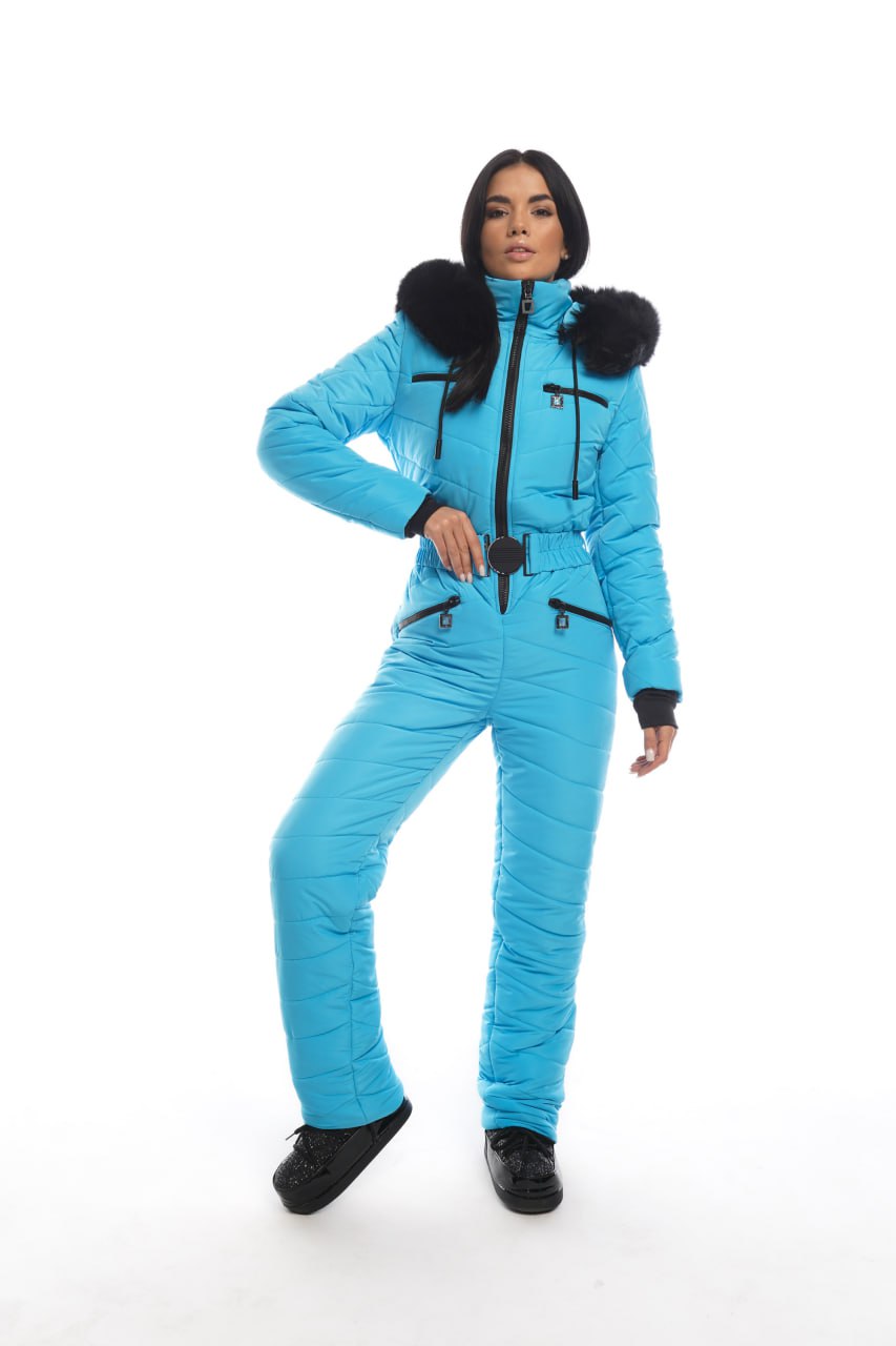 Person wearing a blue snowsuit with black fur trim on a white background