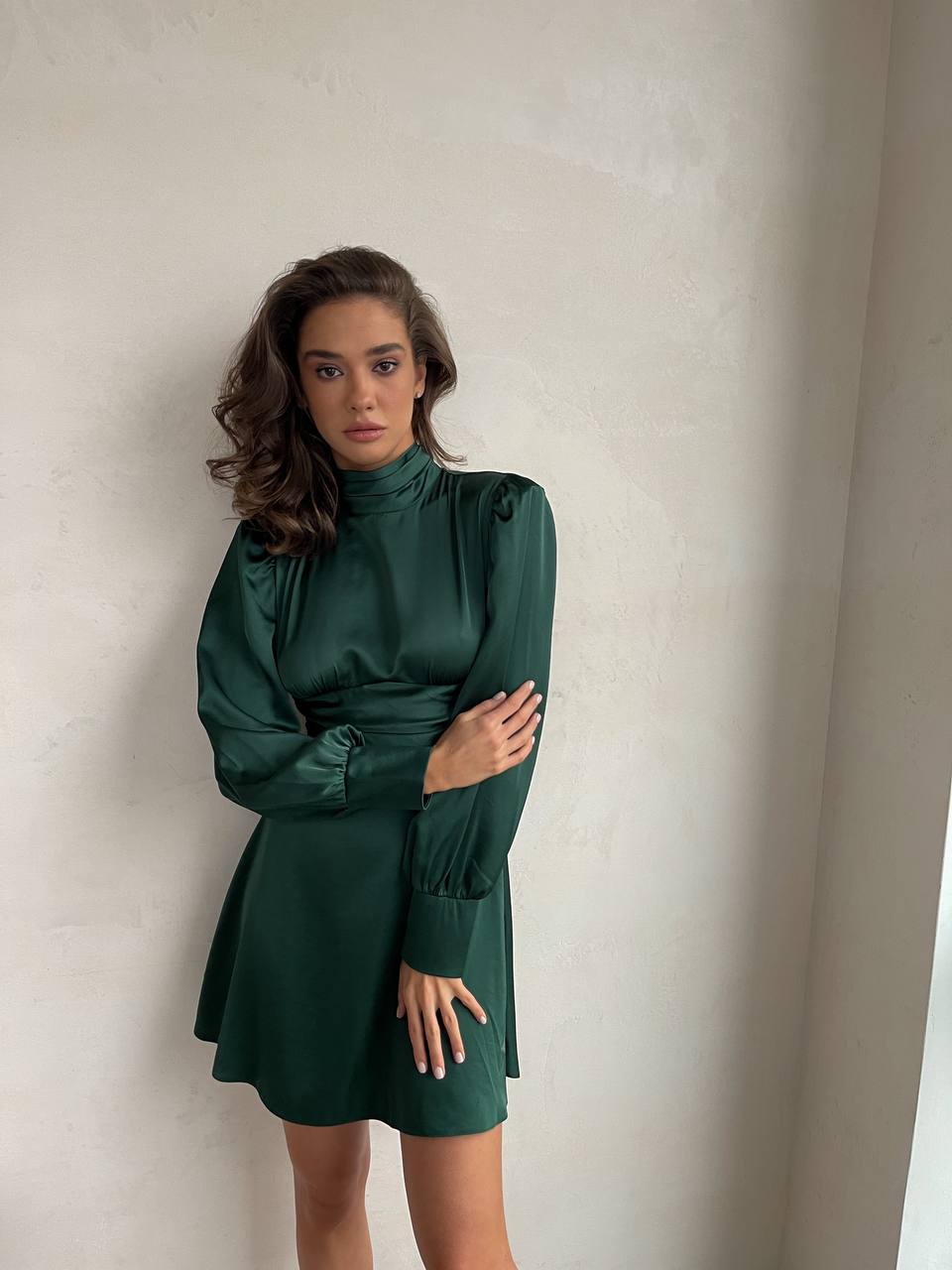 Woman wearing a green dress against a plain background