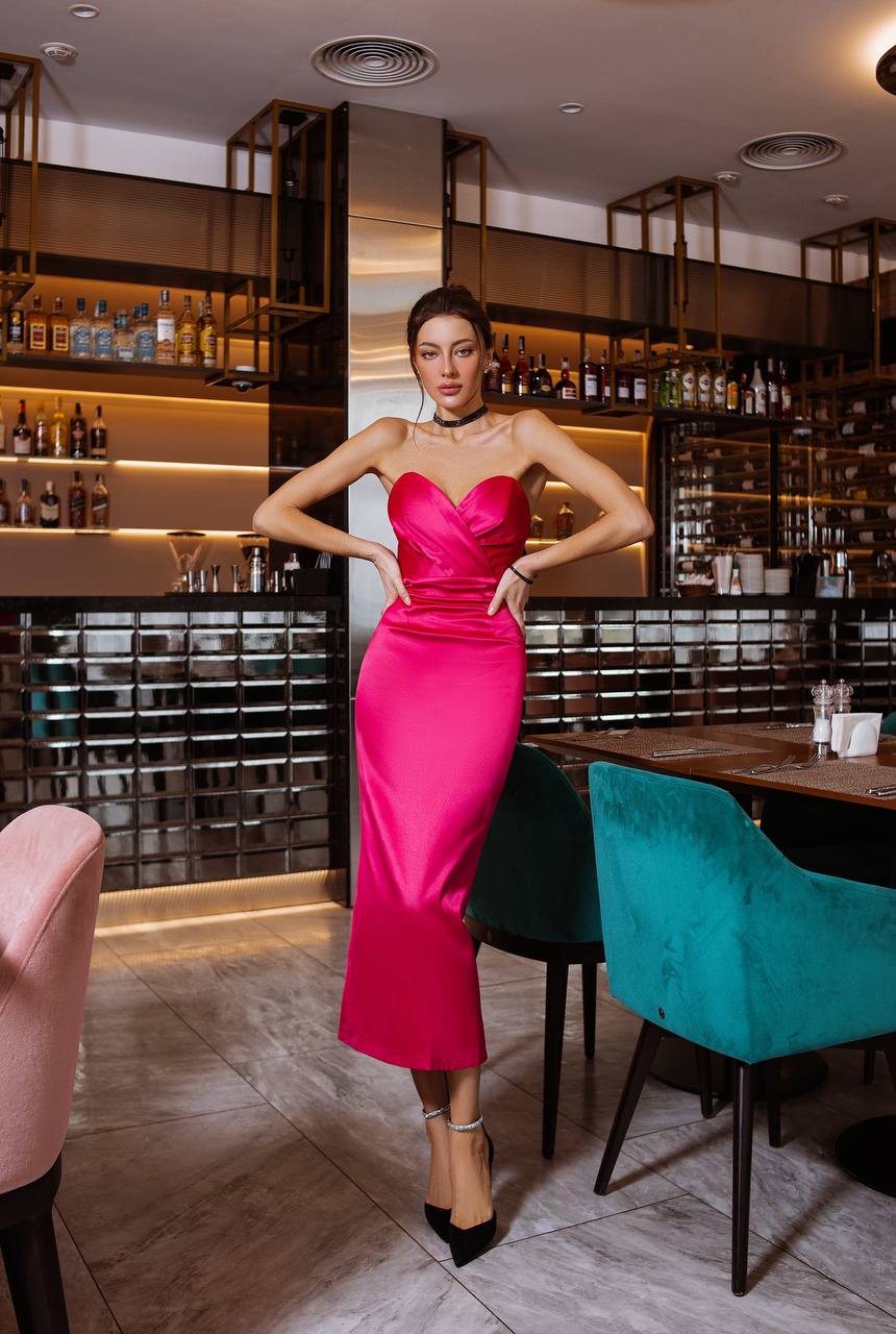 Woman in a pink dress standing in a bar setting