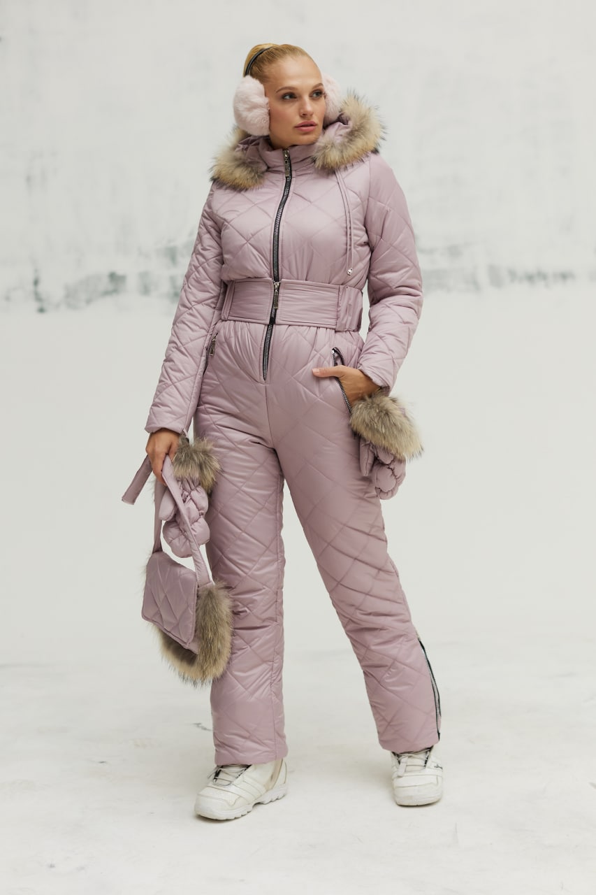 Person wearing a pink snowsuit with fur accents in a snowy landscape