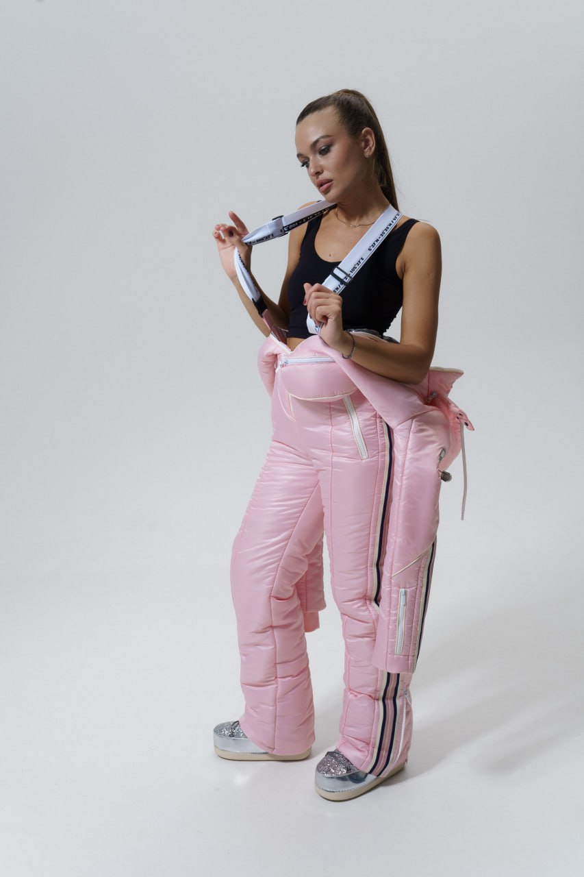 Person wearing pink tracksuit with white stripes on a plain background