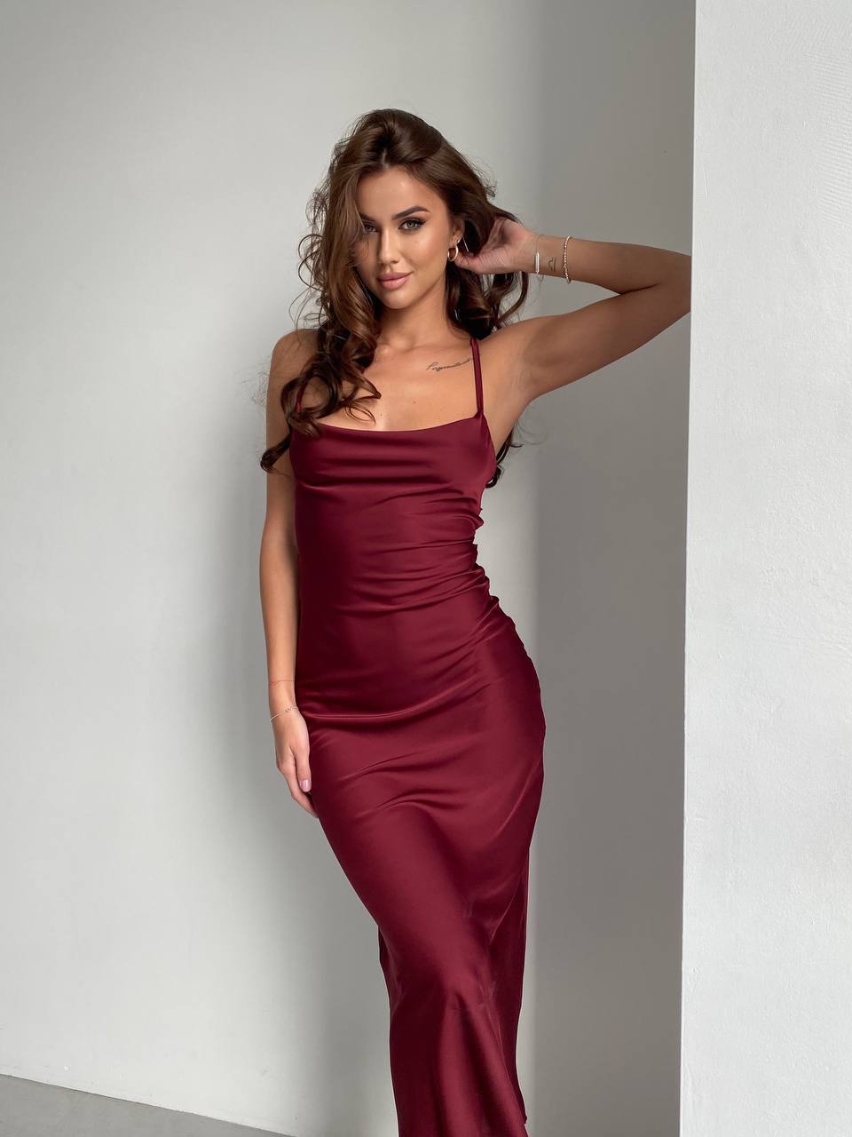 Woman wearing a burgundy dress against a plain background