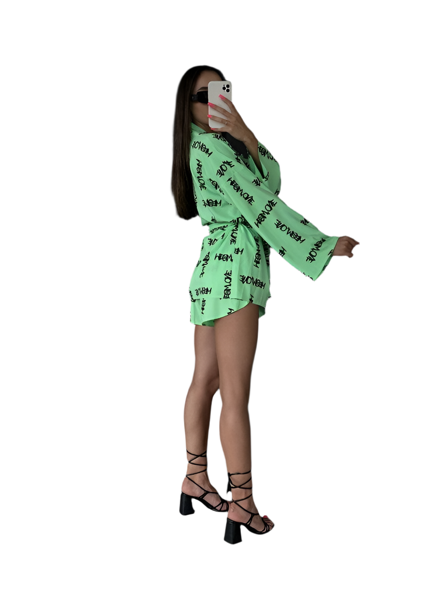 Person wearing a bright green outfit with text pattern on a white background