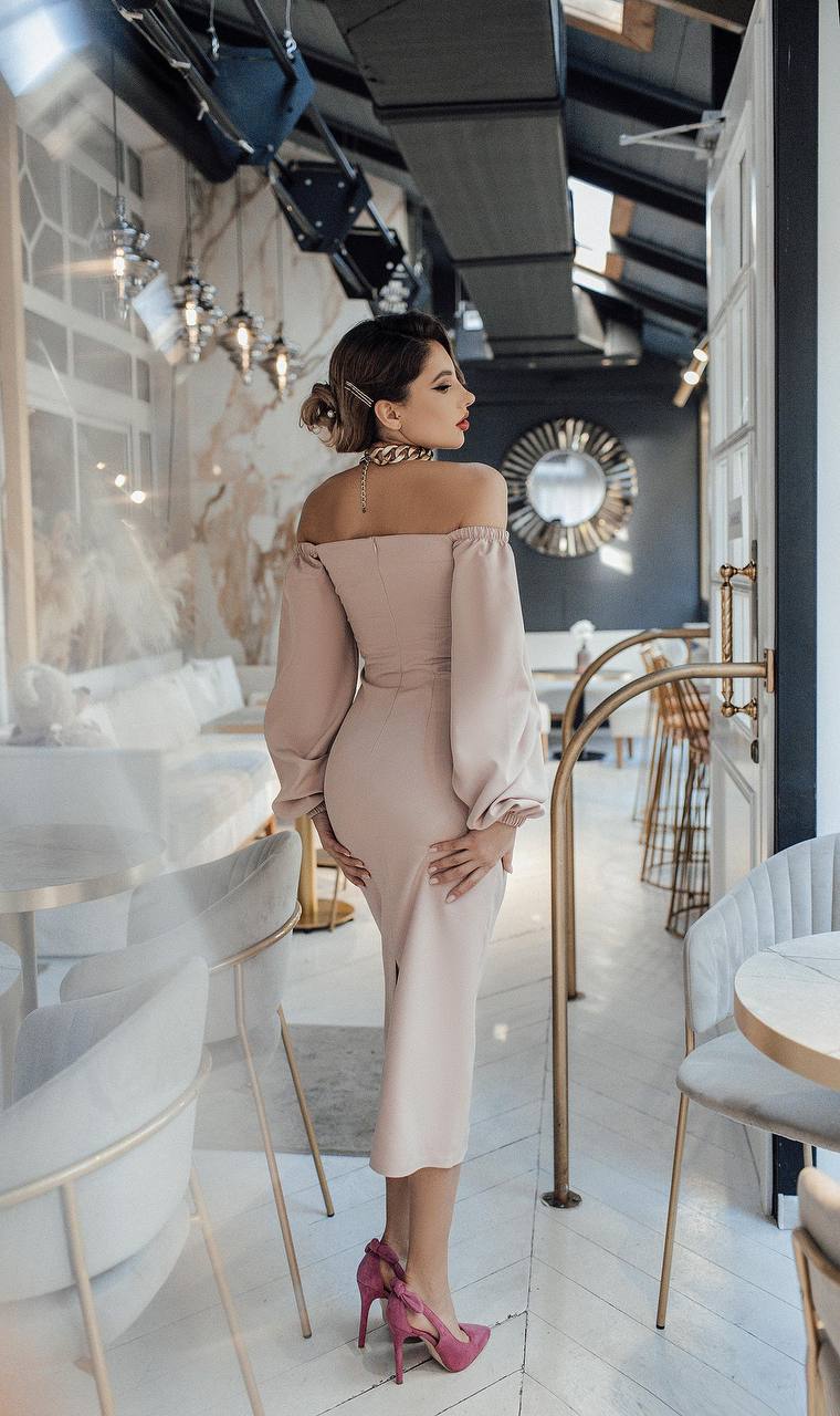 Woman in a pink dress standing in an elegant interior setting