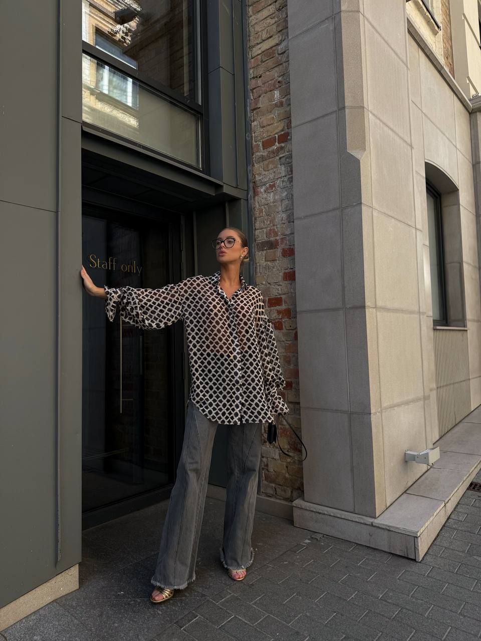 Woman standing on a city street next to a building entrance