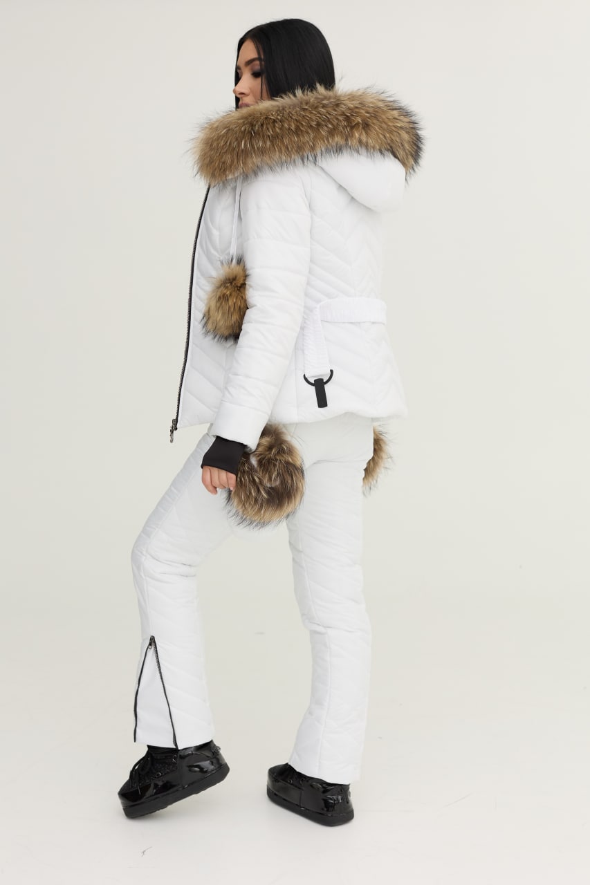 Person wearing a white puffer jacket with fur hood and cuffs on a plain background