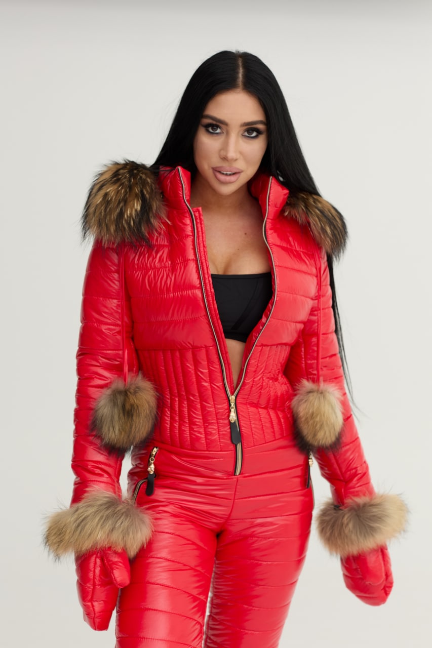 Person wearing a red puffer jumpsuit with fur trim on a white background